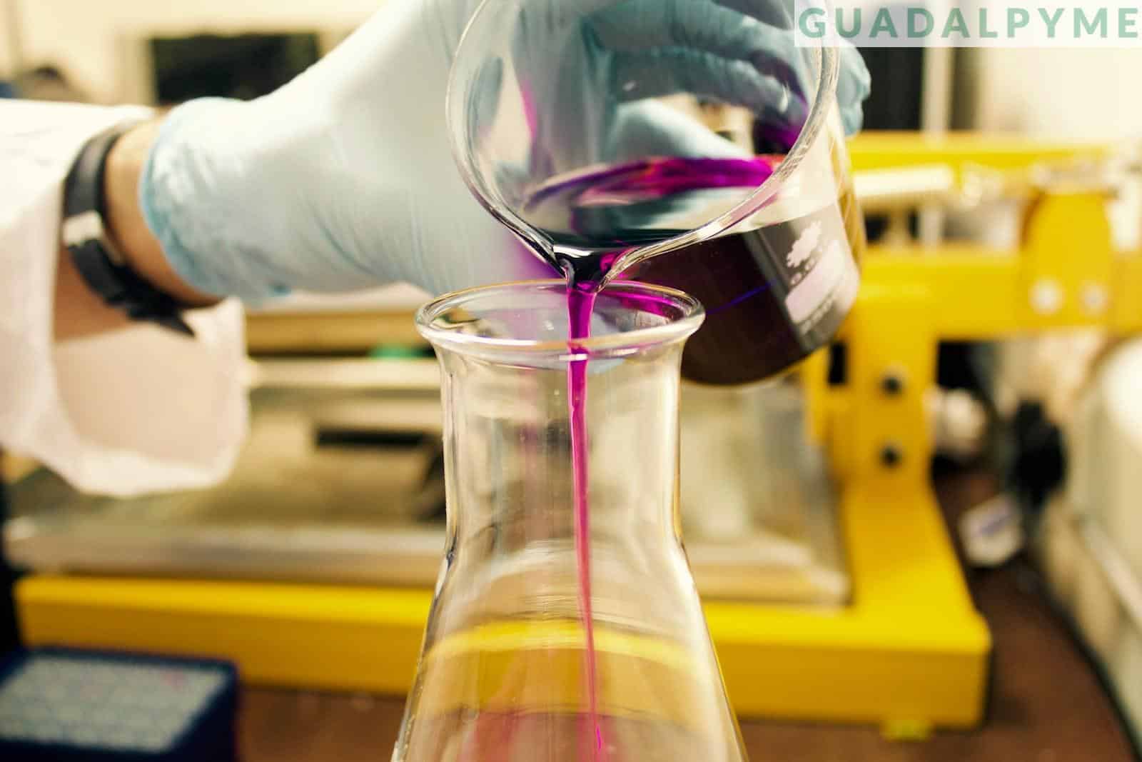 person pouring purple liquid on clear glass container